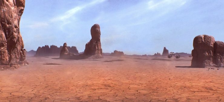 Image of the desert planet Tatooine  in Star Wars: The Phantom Menace. Podracers fly above Tatooine's salt flats, between tall rocks known as yardangs.